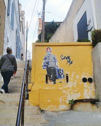 Man with graffiti on wall in city