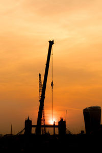 Silhouette crane against sky during sunset