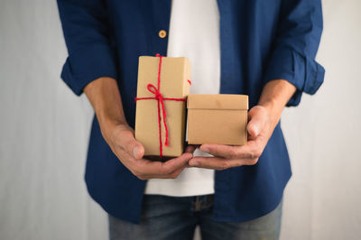 Midsection of man holding paper in box