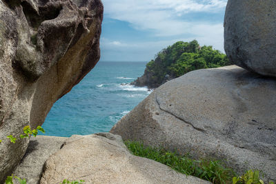 Rock formation on sea shore against sky