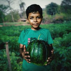 Portrait of boy holding plant