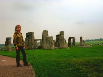 Young man with blonde dreadlocks at stonehenge.