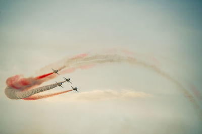 Low angle view of airshow against sky