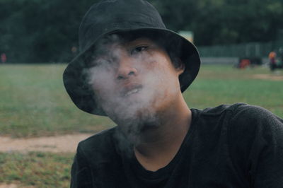 Close-up portrait of young man exhaling smoke