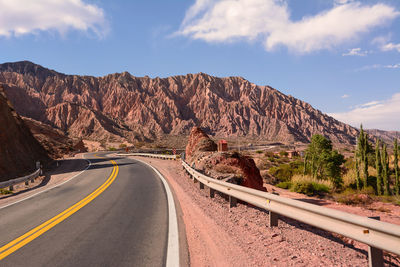 Road by mountain against sky