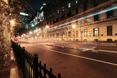 Light trails on road along buildings at night