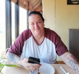 Portrait of smiling woman sitting on table