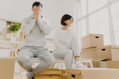 Couple sitting on table in room