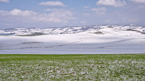Scenic view of snow covered field against sky