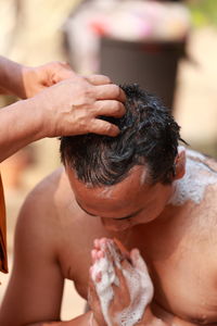 Close-up of shirtless man holding hands