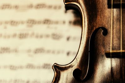 Close-up of violin against musical note