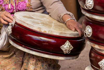 Midsection of woman playing drum