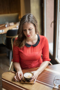 Beautiful young woman having coffee at cafe