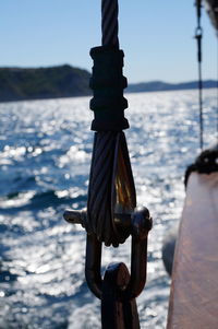 Close-up of rope tied to wooden post on beach