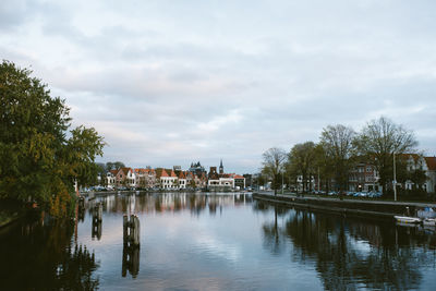 View of river in town against cloudy sky