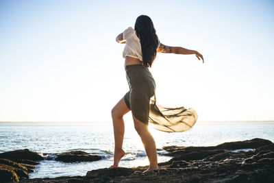 Full length of man on beach against clear sky