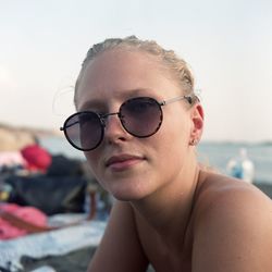 Close-up portrait of woman wearing sunglass against sky