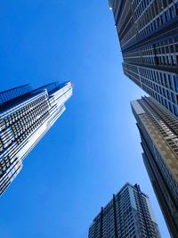 Low angle view of modern buildings against clear blue sky