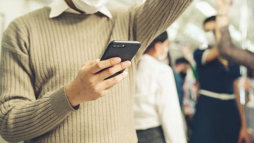 Midsection of man using mobile phone