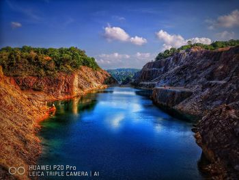 Scenic view of river and mountains against blue sky