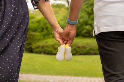 Couple holding baby shoes for baby shower 