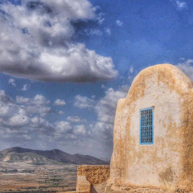 sky, cloud - sky, built structure, building exterior, architecture, cloud, mountain, cloudy, landscape, house, blue, nature, day, scenics, beauty in nature, tranquility, tranquil scene, outdoors, no people, mountain range