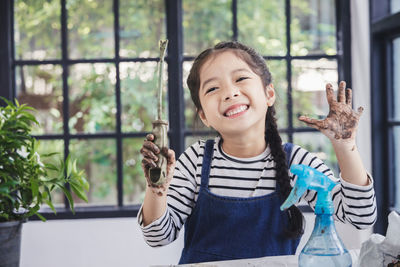 Portrait of smiling girl holding window