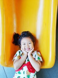 High angle portrait of cute girl touching cheek on slide