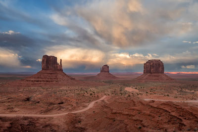 View of rock formations on landscape against cloudy sky