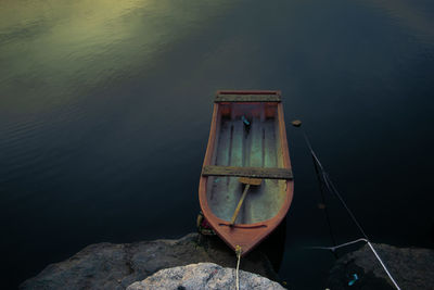 High angle view of boat moored on rock by lake