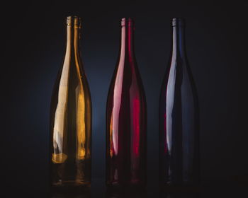 Close-up of wine bottles against black background