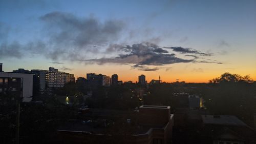 High angle view of silhouette buildings against sky during sunset