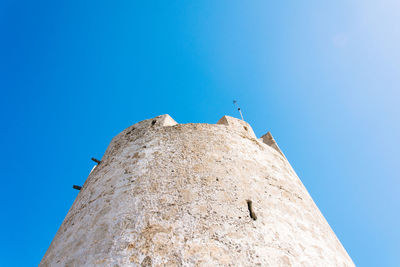 Low angle view of a tower against clear blue sky