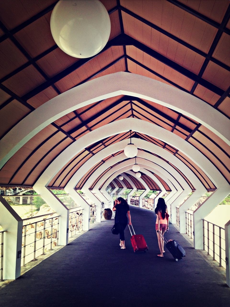 indoors, lifestyles, men, architecture, leisure activity, full length, built structure, ceiling, person, walking, rear view, casual clothing, the way forward, arch, tunnel, togetherness, travel, boys