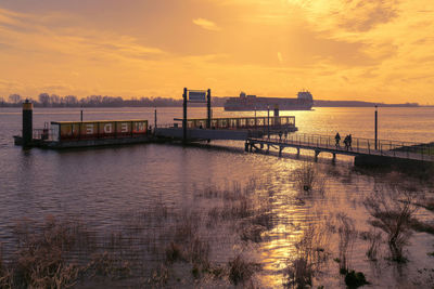 Pier over sea against sky during sunset