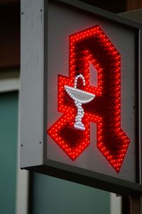 Close-up of illuminated text on red wall