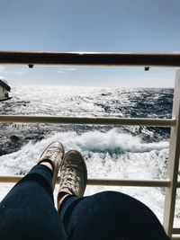 Low section of man in sea against sky