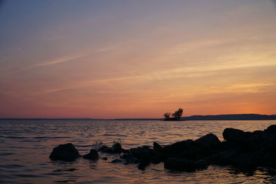 Scenic view of lake against romantic sky at sunset