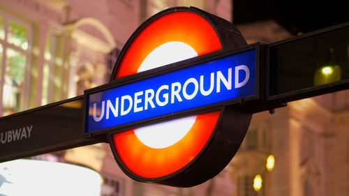 Low angle view of road sign against illuminated city