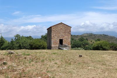 Built structure on field against sky