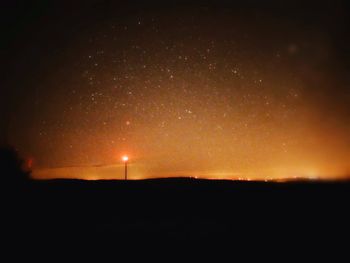 Silhouette landscape against sky at night