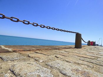 Close-up of beach against clear blue sky