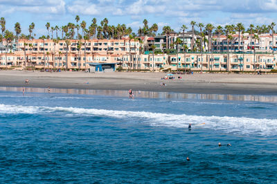 Scenic view of sea against buildings in city