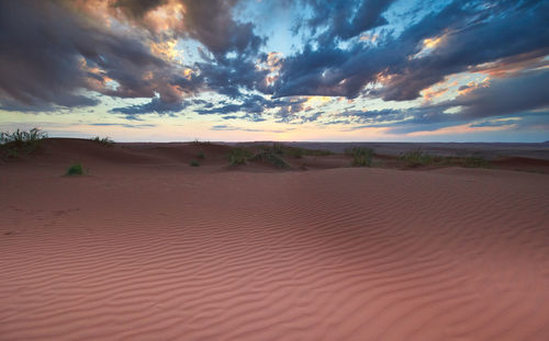 Scenic view of desert against sky during sunset