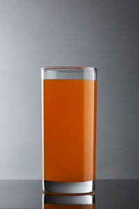 Close-up of beer glass against orange background