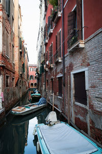 Boats amidst buildings on canal in city 