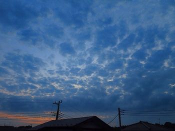 Low angle view of silhouette roof against sky