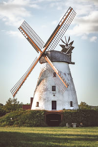 Traditional windmill on field against sky