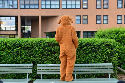 Rear view of woman standing against building