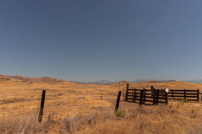 Wooden fence on field against sky